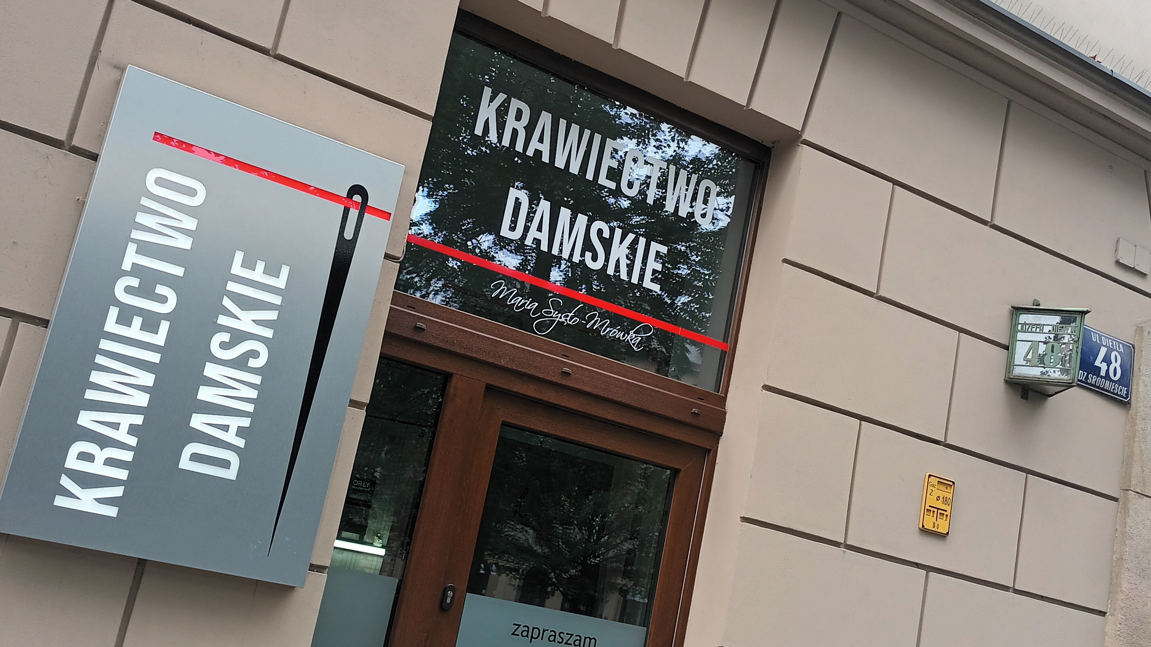 Szyld i wejście do pracowni krawieckiej przy ul. Dietla 48